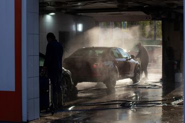 Kaksi henkilöä pesee autoja